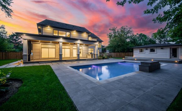 Twilight backyard with pool and waterfall feature at 2014 Lakeshore Rd W in Bronte, Oakville.